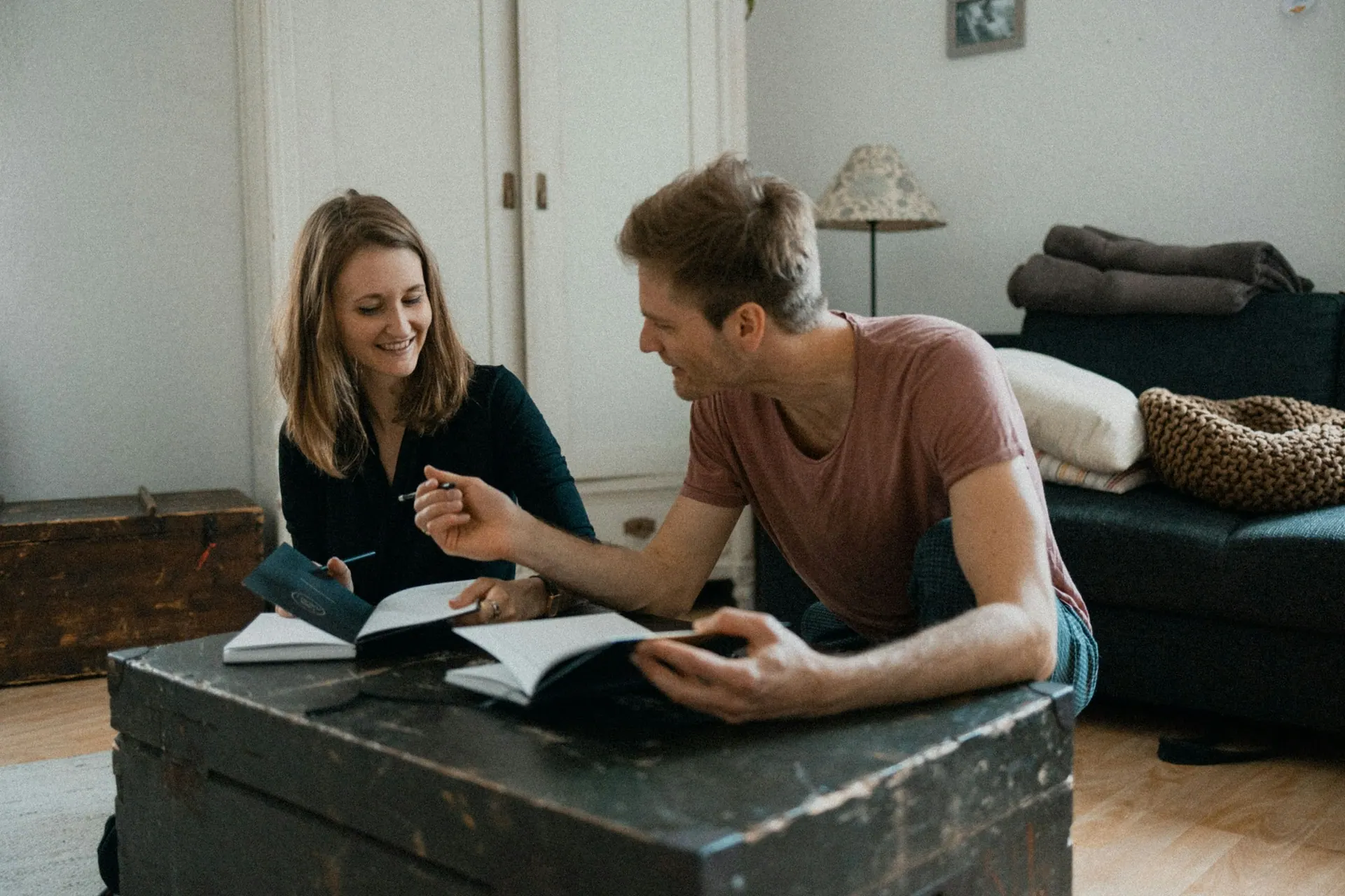 A coach and client talking over an open journal in warm light
